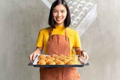 Portrait of a smiling young woman holding food