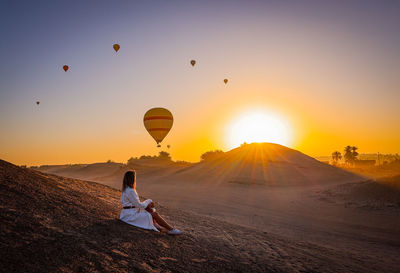 Hot air balloons flying against sky during sunset