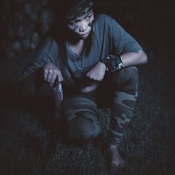 Full length of boy crouching on field