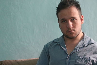 Portrait of young man against wall