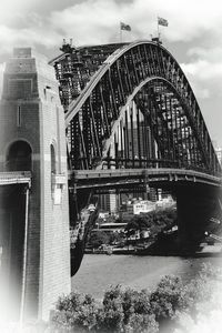 Arch bridge over river in city against sky