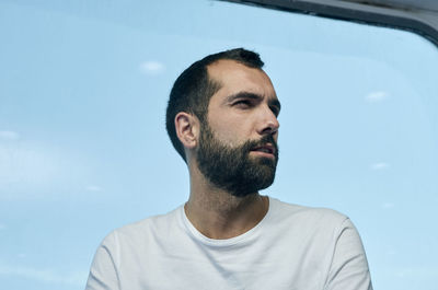 Portrait of man looking away against sky