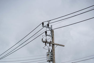 Low angle view of electricity pylon against sky