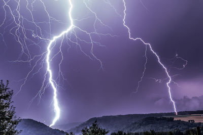 Low angle view of lightning against sky at night