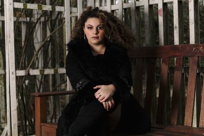 Portrait of beautiful woman standing against railing