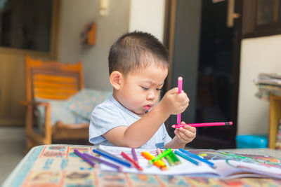 Boy drawing on table at home