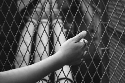 Close-up of hand on chainlink fence