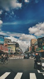 Cars on road against sky in city