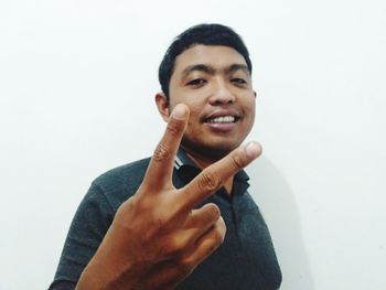 Portrait of smiling young man against white background