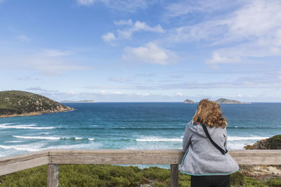 Rear view of woman looking at sea against sky