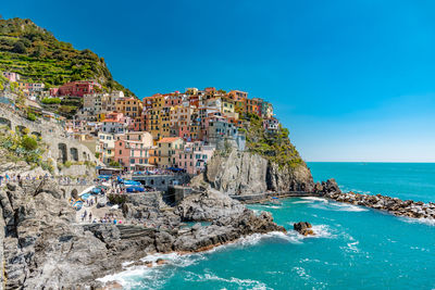 Panoramic view of manarola against clear blue sky