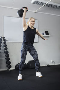 Blond woman lifting weights in gym