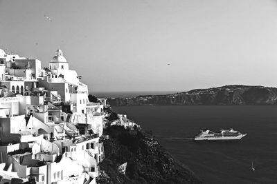 Scenic view of sea and buildings against clear sky