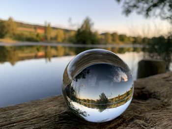 Upside down image of crystal ball on lake