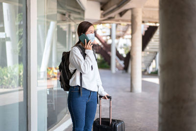 Full length of woman using mobile phone