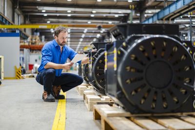 Businessman examining machinery at factory