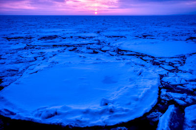 Scenic view of frozen sea against sky during sunset