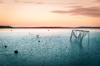 Scenic view of lake against sky at sunset