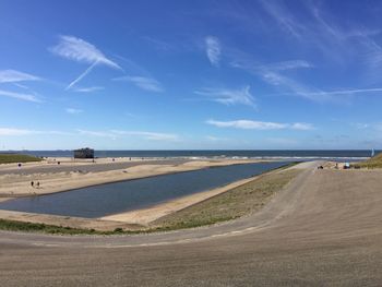 View of calm beach against blue sky