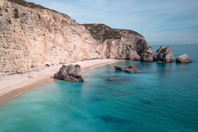 Scenic view of rocks in sea against sky