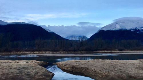 Scenic view of lake and mountains against sky