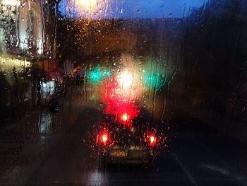 Illuminated street seen through wet glass window