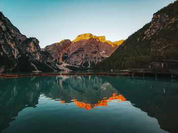 Scenic view of lake and mountains against sky during sunset