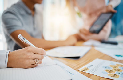 Midsection of business colleagues working at table