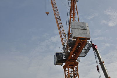 Low angle view of crane against sky