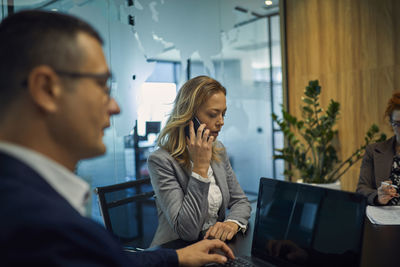 Businesswoman on cell phone during a meeting