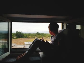 Child looking through  window