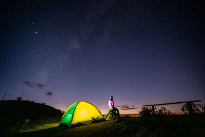 People standing on field against sky at night