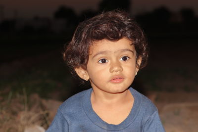 A closeup portrait photo of beautiful hindu little male boy playing in garden at sunset , india