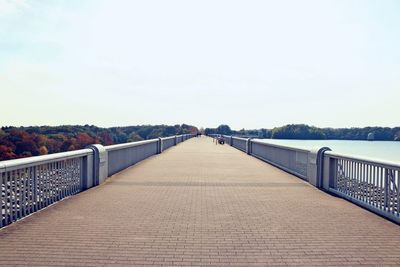 Surface level of footbridge against clear sky