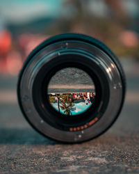 Reflection of palm trees in camera lens at beach