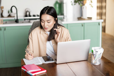 Young woman using laptop at home