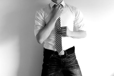 Midsection of man standing against white background