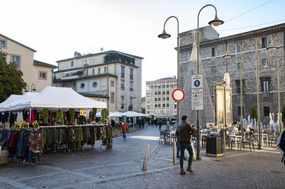 People walking on street against buildings in city