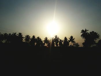 Silhouette palm trees against sky during sunset