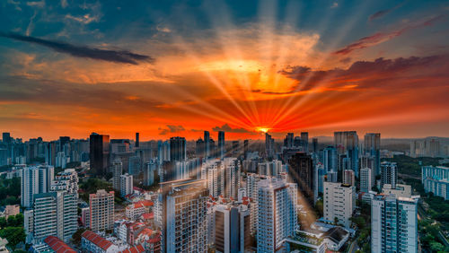 Aerial view of modern buildings against sky during sunset