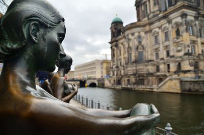 Woman's statue looks at the berlin cathedral