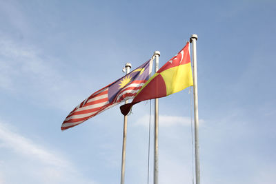 Low angle view of flags against blue sky