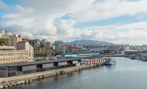 River amidst buildings in city against sky