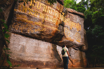 Man standing on rock against trees