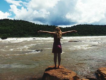 Woman standing on beach against sky