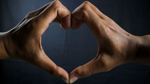 Cropped hand of man against black background