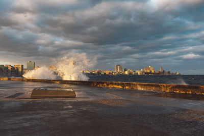 Sea by buildings against sky in city