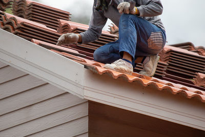 Low angle view of men sitting on roof