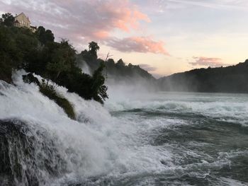 Scenic view of waterfall against sky