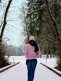 Woman walking on snow covered landscape